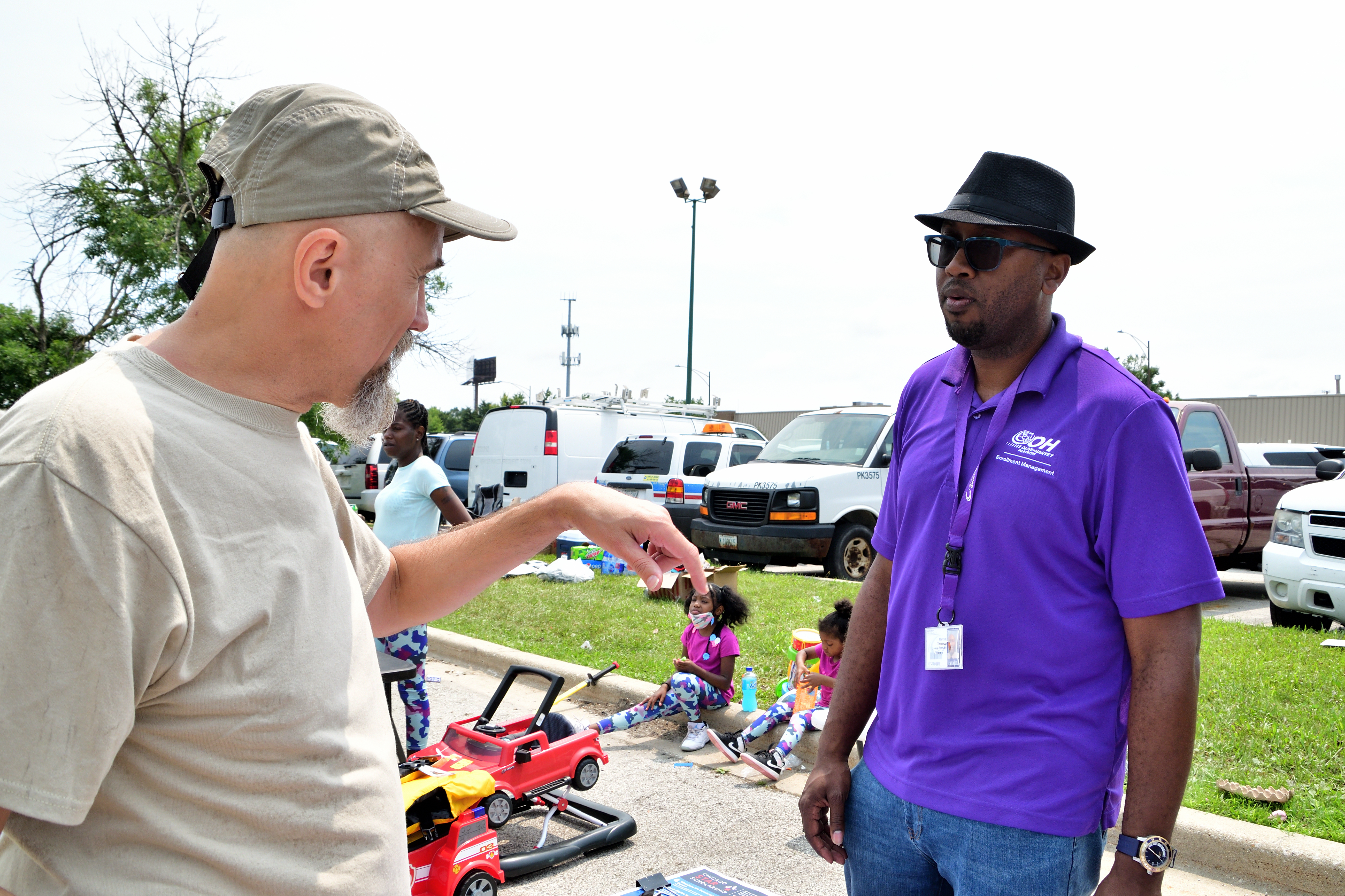 Dr. John Kugler talking to Olive Havey College Representative Marcus Troutman, Community Festival 2021, 5th District Chicago Police Headquarters, July 17, 2021 (pic by Emi Yamamoto)