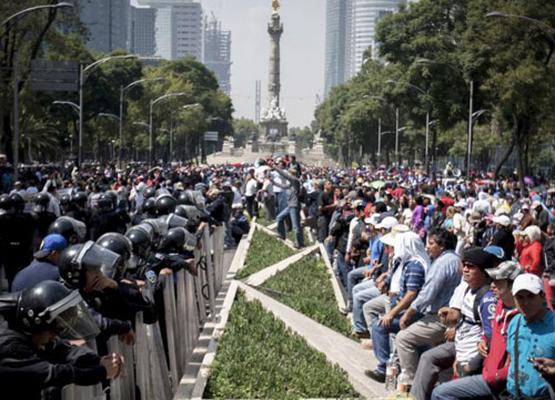 Mexican teachers (right) were standing up against corporate 