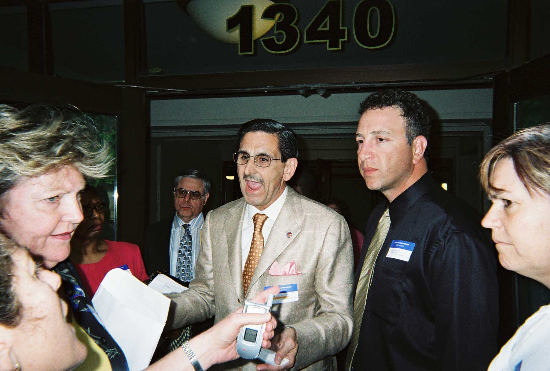 June 1, 2005. Chicago Teachers Union Vice President Ted Dallas (above, center) talks with irate union members including School Clerk Delegates Maureen Callaghan (left) and Schurz High School Delegate Lois Jones (right) after someone from the CTU leadership tried to have former CTU President Deborah Lynch arrested. The verbal and sometimes physical attacks on Lynch during Marilyn Stewart’s first term (2004-2007) have long been compared to the dirty tricks conjured up for the Bush Administration in Washington, D.C., by Karl Rove. Of all the dirty tricks, the nastiest came with the arrest of Lynch, who was escorted out of the House meeting by two armed Chicago police officers. At the time, several observers believed that Dallas had called the police, and the police told Substance reporter George Schmidt that the call came from someone identifying himself as the “vice president.” Dallas claimed that he had not called the police. Lynch was released from police custody after CTU officials refused to sign the arrest complaint that she had been “disorderly” during the House of Delegates meeting. Others in the photograph above are CTU security coordinator Rick Perrote (behind Dallas), who is now an officer of the Marilyn Stewart faction of the “UPC,” and Ted Hajiharis (a field rep, to the right of Dallas). Two complete stories about the incident (“Scofflaw Union Chiefs Run Outlaw Meeting” by Theresa Daniels and “CTU officials attempt to arrest Deborah Lynch” by George N. Schmidt are still available on the “old” Substance Website at www.substancnews.com. The new Substance site is www.substancenews.net. Substance photo above from the June 1, 2005 CTU meeting by George N. Schmidt.